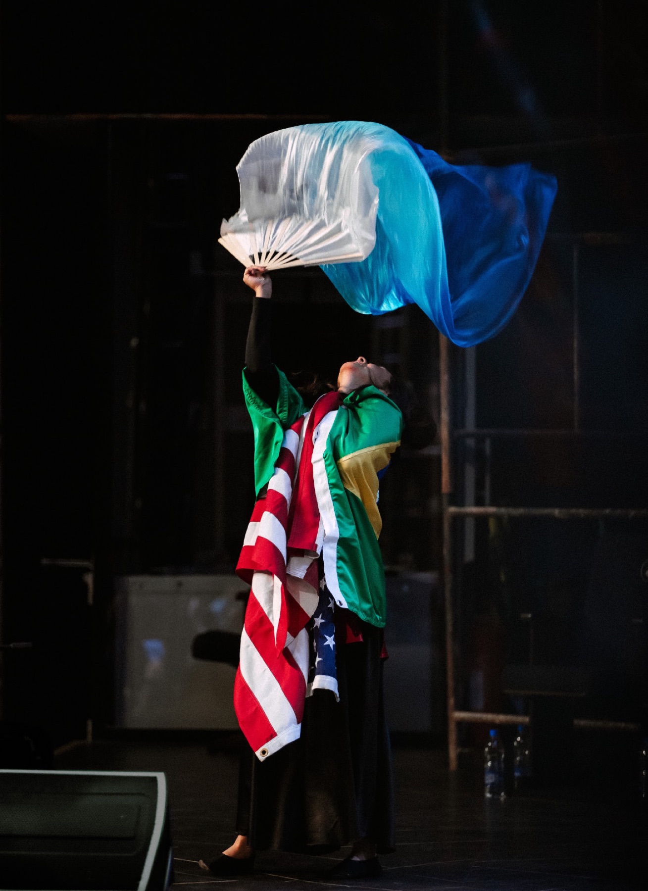 A worshipper dancing with flags under stage light