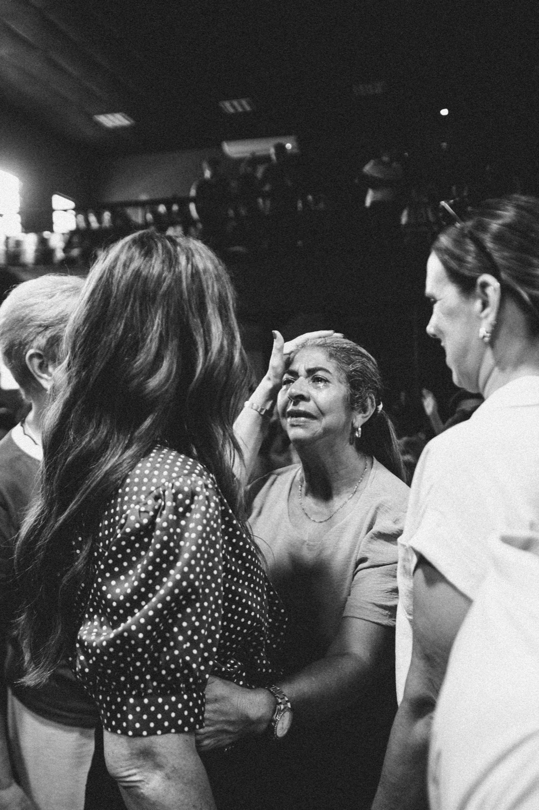 A believer being prayed over, hands laid on in ministry, in black and white