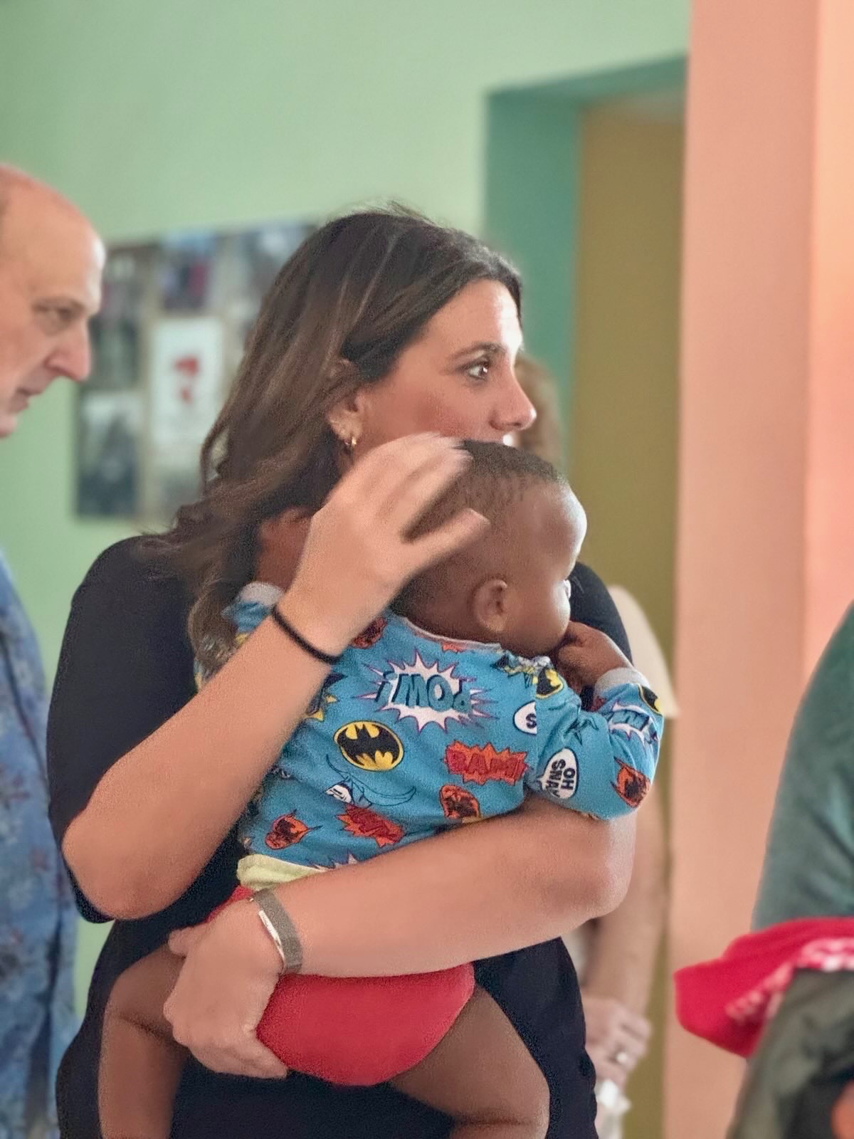 A team member holding a small child on the mission field