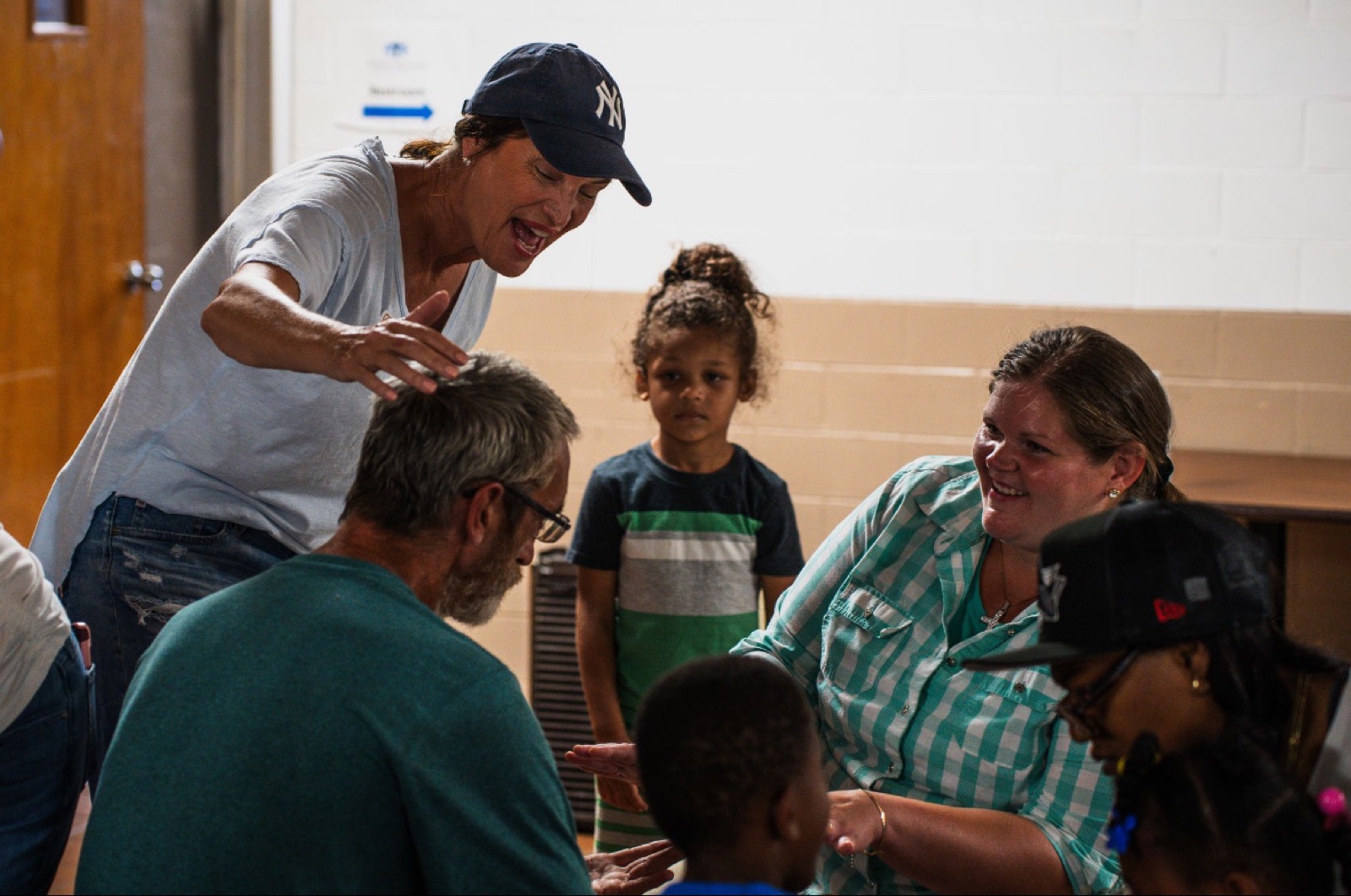 A woman laughing with a family and their children