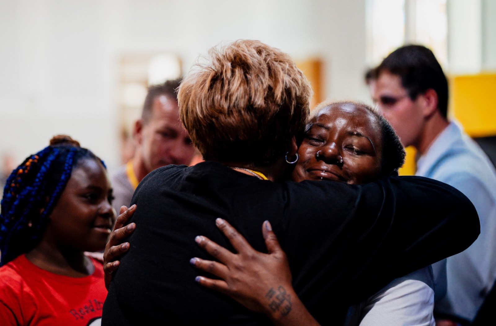 Two women embracing after prayer