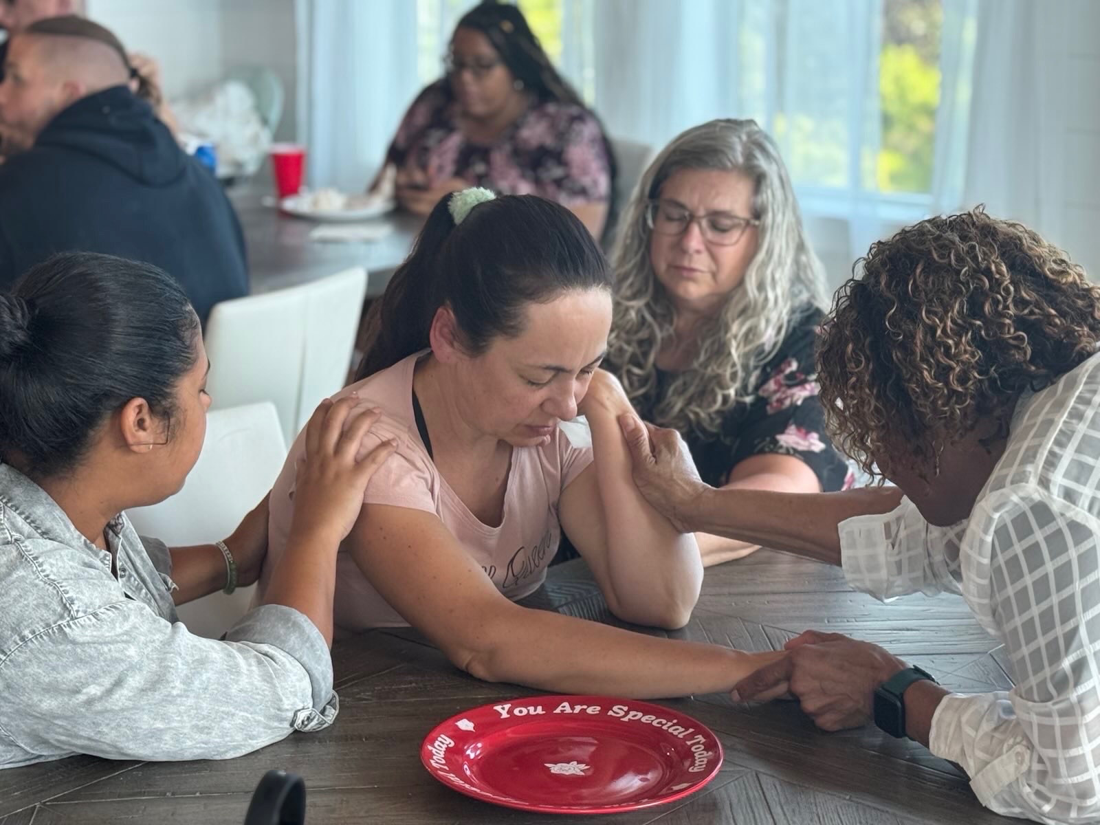 A small group praying together around a table